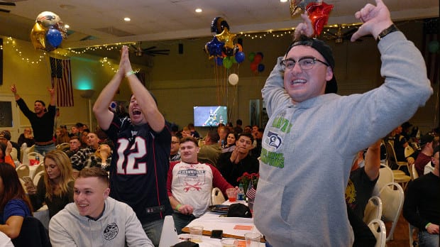 Marines Ken R. Yergen, right and Daniel Biedrzyck, center, celebrate a Patriots touchdown as Gary and Julie Crisp of Orange County hold their 10th Annual all-day Super Bowl party Saturday, Jan. 3, 2019 at the American Legion in Newport Beach
