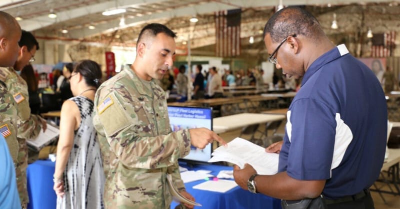 James Montgomery, right, management analyst, Naval Supply Systems Command Fleet Logistics Center Pearl Harbor, discusses resume writing techniques with a service member during a "Hiring our Heroes" transition summit at Schofield Barracks