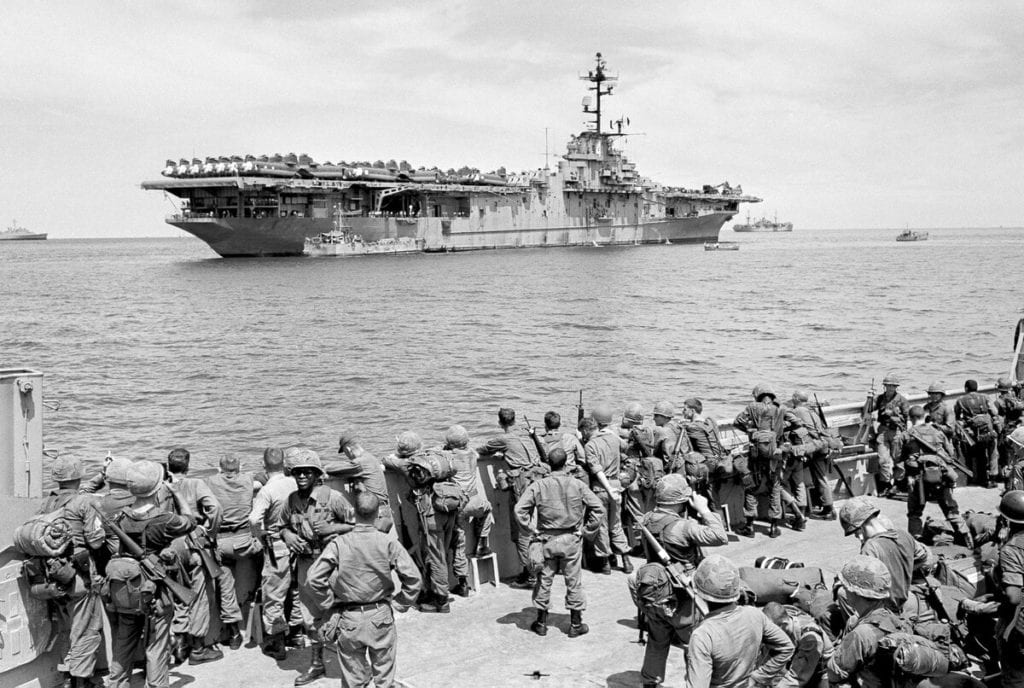Troops from the First Cavalry Air Mobile Division watch the carrier USS Boxer after arrival at Qui Nhon, Vietnam, on Sept. 12, 1965. (AP file photo)