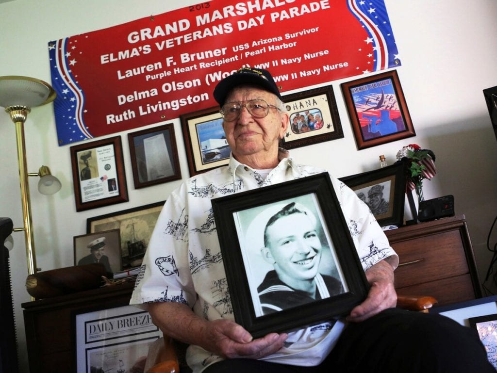 Lauren Bruner, a survivor of the USS Arizona which was attacked on Dec. 7, 1941, holds with a 1940 photo of himself