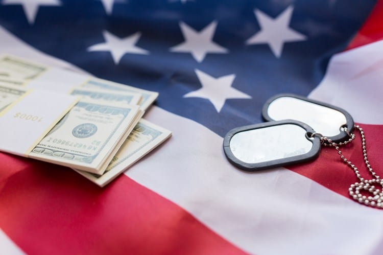 money and dog tags atop an american flag