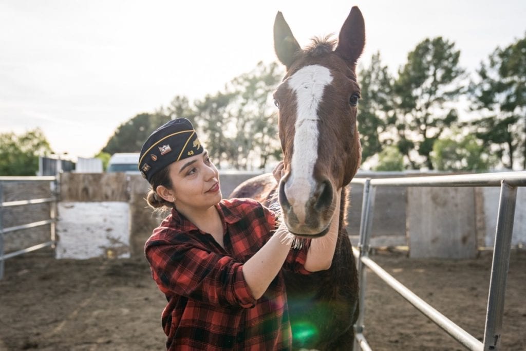 Legionnaire poses with a horse at Warriors Road at Dark Horse Ranch in Sun Valley