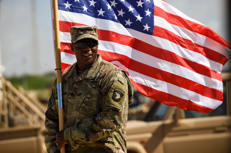 U.S. Army Staff Sgt. Anthony Miller with the 101st Airborne Division holds the American flag during a graduation ceremony for Somali soldiers, May 24, 2017, in Mogadishu, Somalia. The soldiers completed a course focused on various aspects of logistics. NICHOLAS BYERS/U.S. AIR FORCE