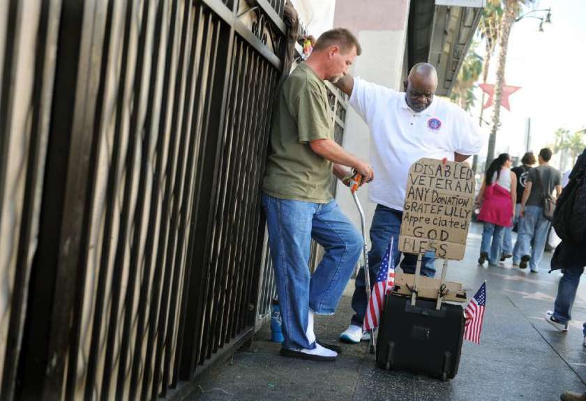 A charity worker speaks with a Vietnam veteran on Sunset Boulevard. An estimated 6,300 veterans who live in Los Angeles County are homeless. (Los Angeles Times)