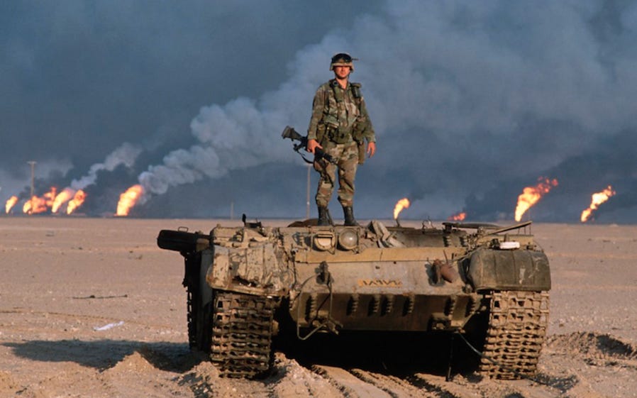 A US soldier stands on top of a destroyed tank during the Gulf War. (Photo: Renee L. Sitler/U.S. Army)