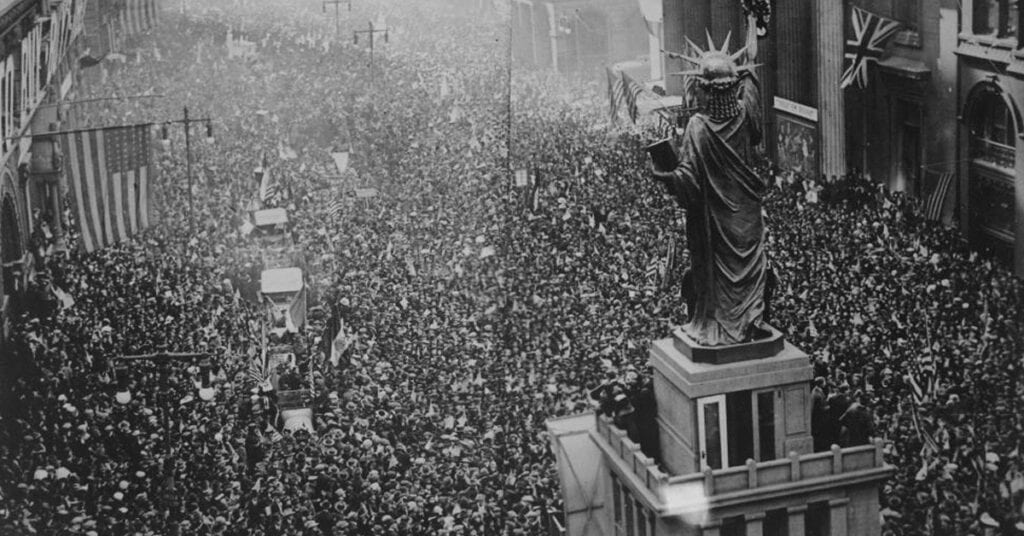 crowd of people gathered around the Statue of Liberty