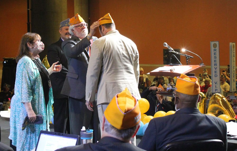 Ned Fox caps his son, Michael, elected National commander of the Sons of The American Legion. (Photo: Bill Towns)