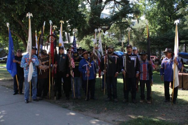 Native American veterans holding tribal, U.S., and California flags