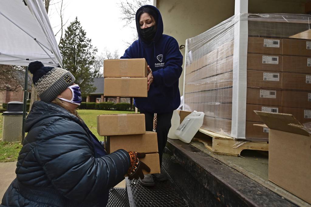 Officials with the Youngstown Health District unload boxes of at-home COVID-19 test kits during a distribution event on Dec. 30, 2021, in Youngstown, Ohio. (David Dermer/AP)