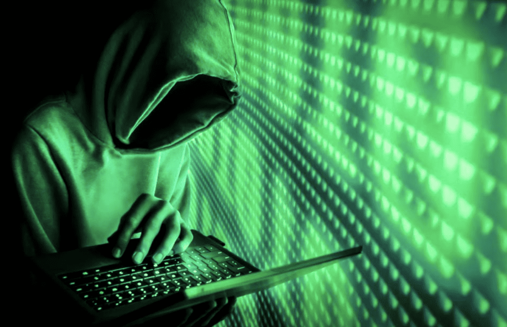 hacker in a hoodie on green futuristic background
