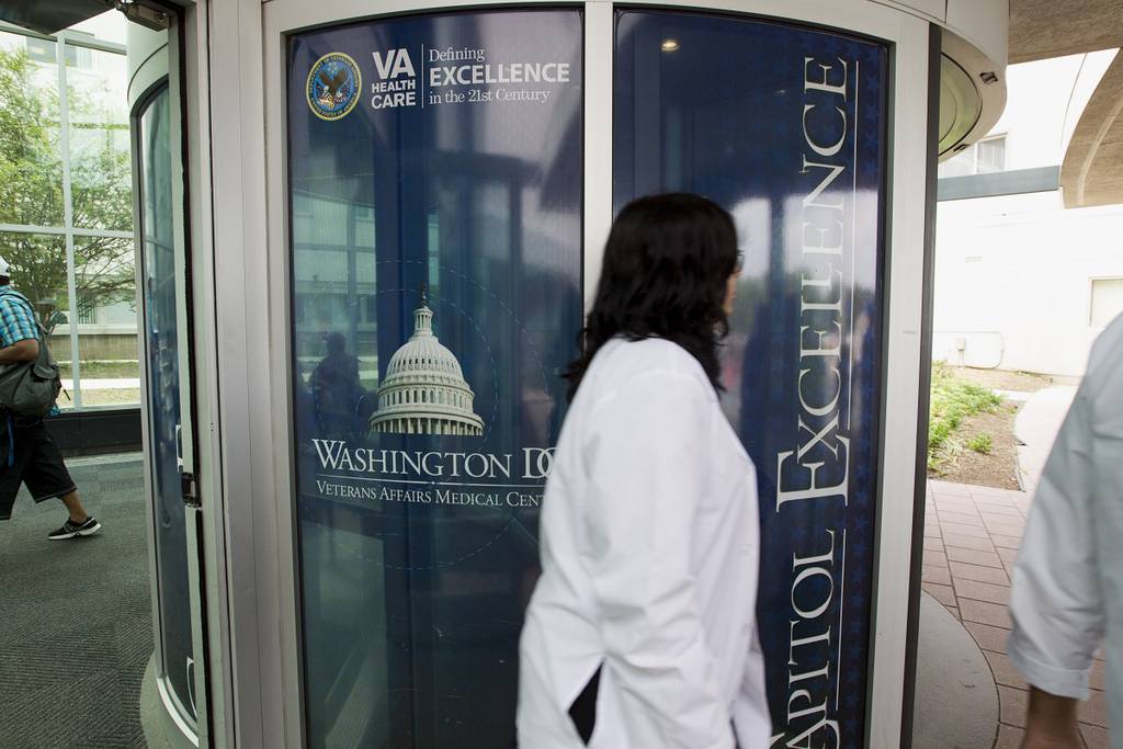 Staffers walk part the entrance of the Washington D.C. Veterans Affairs Medical Center in June 2014. (Jose Luis Magana/AP)