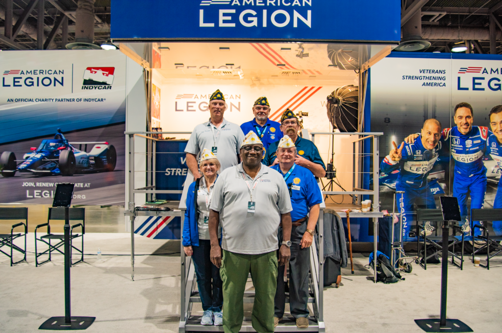 group gathered in front of an American Legion booth at the Long Beach Grand Prix