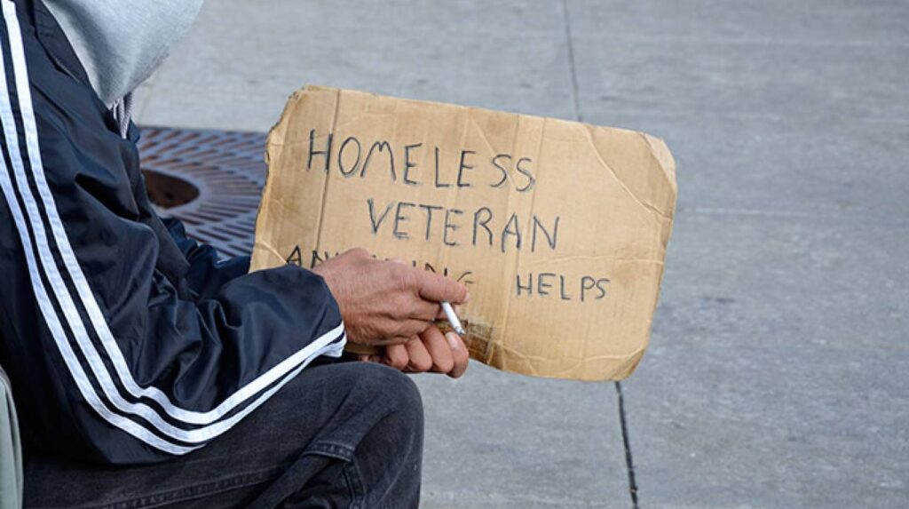 homeless veteran with sign