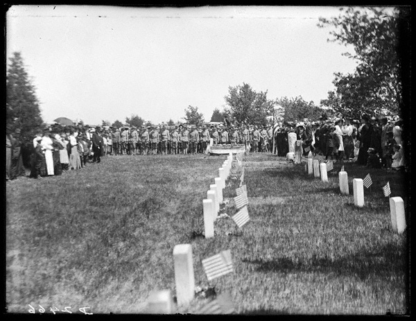 black and white photo of rows of American flags next to the graves of fallen American Civil War soldiers