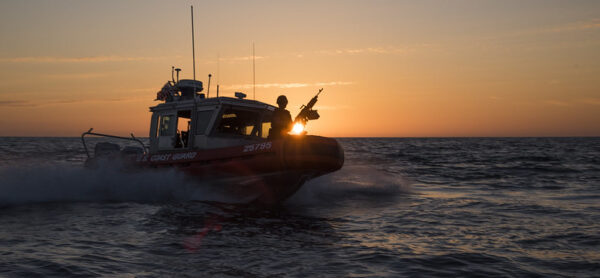 A small U.S. Coast Guard watercraft patrols somewhere near Santa Barbara at sunset