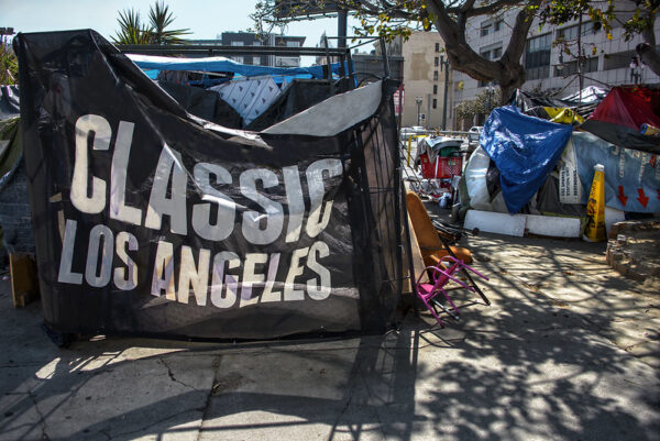 tents in downtown Los Angeles, likely belonging to the homeless. One of the tents has a flag reading "Classic Los Angeles"