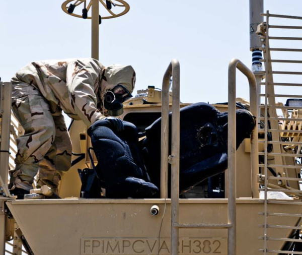 Paratrooper decontaminates Buffalo MRAP after white phosphorus rocket attack in Afghanistan.