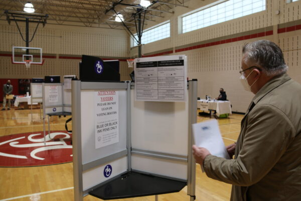 Michael Georg Link examines a voting booth