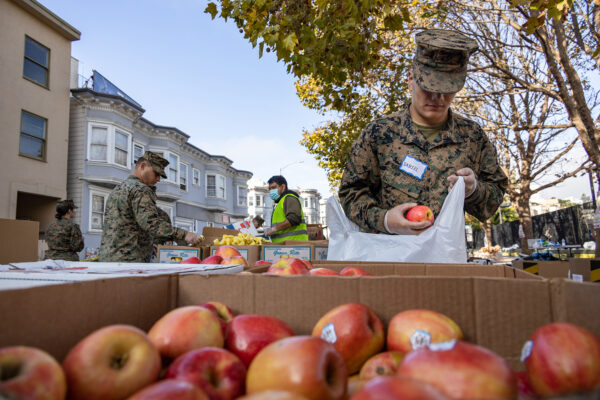 Marines and Sailors prepare bags of food for Food Bank