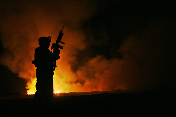Sgt. Robert B. Brown watches over the civilian Fire Fighters at the burn pit in CAMP FALLUJAH, Iraq, 2007.