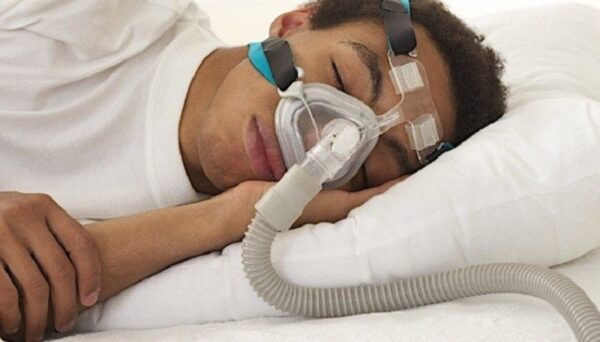 Man wearing a CPAP machine while sleeping