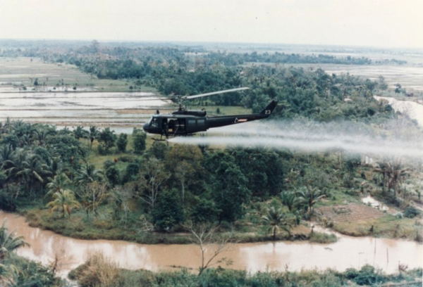 A military helicopter dispersing Agent Orange during the Vietnam War.