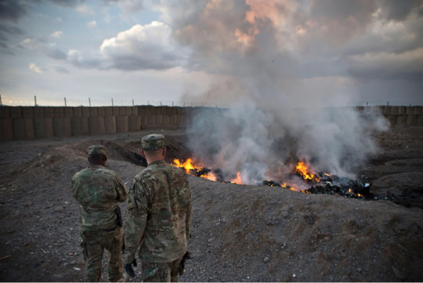 Garbage burns as two U.S. soldiers watch, Afghanistan, 2013