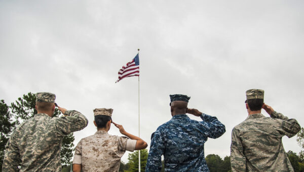 Service members from each branch of the U.S. military salute the American flag during a retreat ceremony on October 2, 2014, at Little Rock Air Force Base